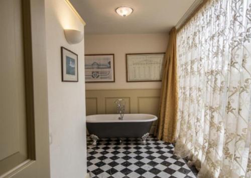 a bathroom with a tub and a shower curtain at Green Hill Property in Besozzo
