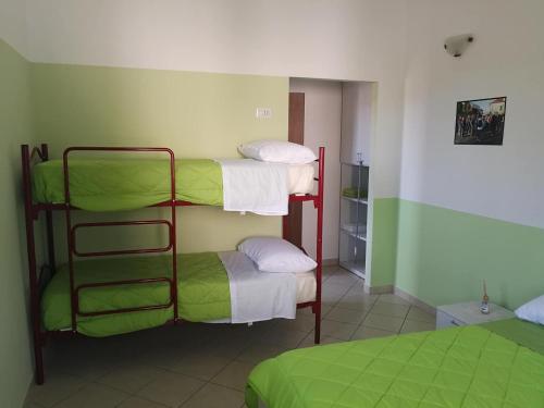 two bunk beds in a room with green walls at OSTELLO DI SAN GERMANO in Borgofranco dʼIvrea