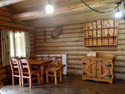 a dining room with a wooden table and chairs at Tsisarske Urochyshe in Rozgirche