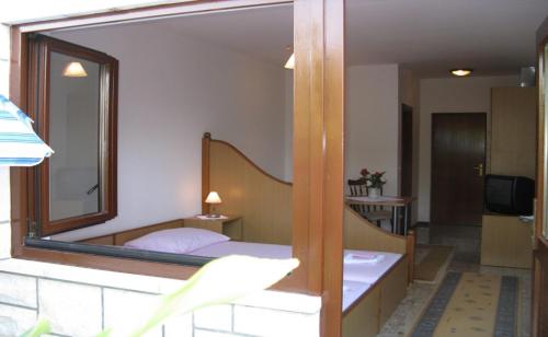 ein Schlafzimmer mit einem Spiegel und einem Bett in einem Zimmer in der Unterkunft Apartments Miho in Orebić