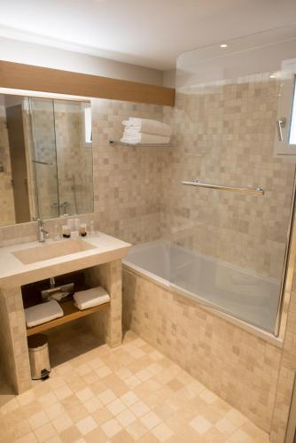 a bathroom with a tub and a sink at Le Fregate Provence in Bandol