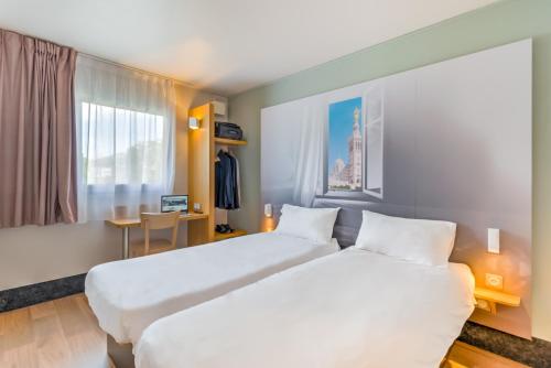 a hotel room with two beds and a window at B&B HOTEL Marseille La Valentine in Marseille