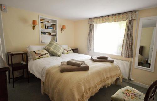 a bedroom with a bed with two towels on it at Grove Cottage in Yarmouth