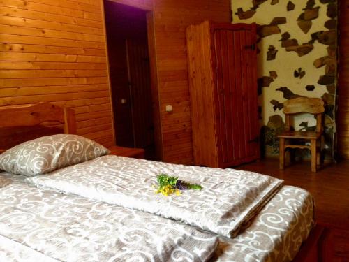 a bedroom with a bed with a flower on it at Tsisarske Urochyshe in Rozgirche