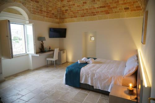 a bedroom with a bed and a table and a window at 5 Elementi Sassi Matera in Matera