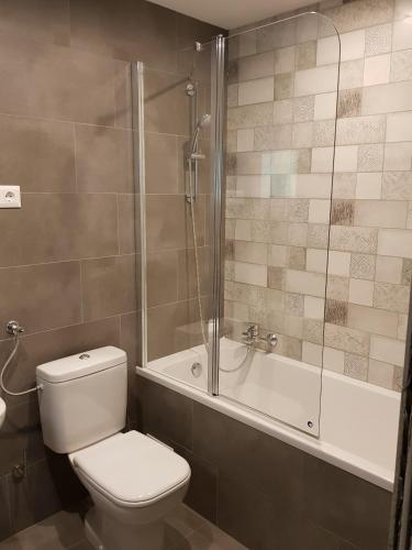a bathroom with a toilet and a shower and a tub at Erdővarázs Panzió in Lillafüred