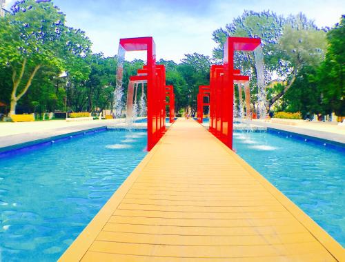 a red bridge in the middle of a pool of water at Villa Garden in Tbilisi City