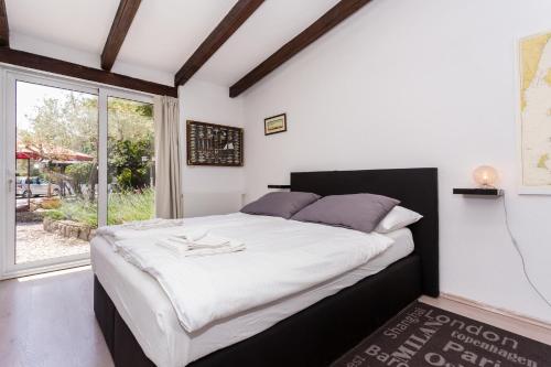 - une chambre avec un grand lit et une grande fenêtre dans l'établissement Molnar Resort Villa Mimoza & Apartment Nea, à Brzac