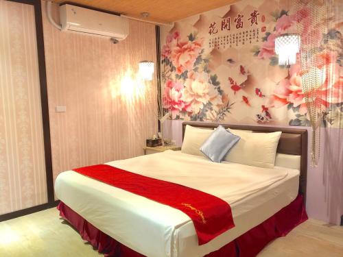 een slaapkamer met een groot bed en bloemenbehang bij Splendid Flora B&B in Hengchun