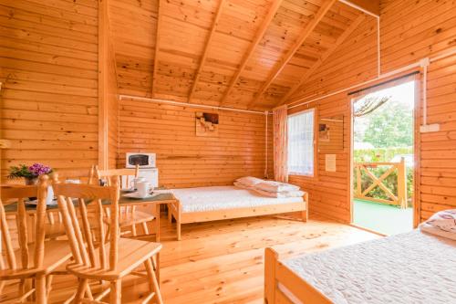 a log cabin with a dining room and a bedroom at Pokoje Pawel Jakubik in Krynica Morska