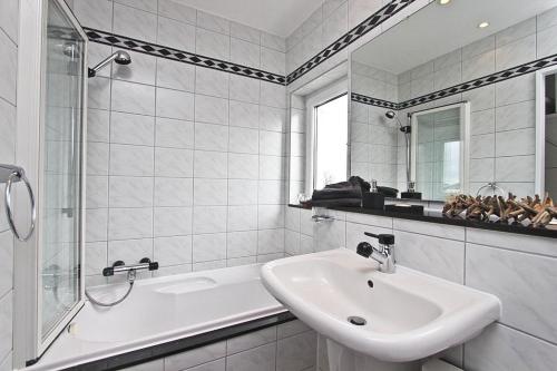 ein weißes Badezimmer mit einem Waschbecken und einer Badewanne in der Unterkunft Apartment Ostseerausch in Scharbeutz