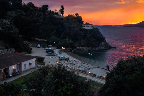 a sunset over a town on a hill next to the water at Hôtel Sampiero in Propriano