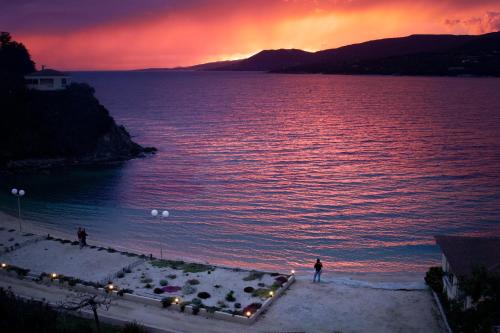 a person standing on a beach at sunset at Hôtel Sampiero in Propriano