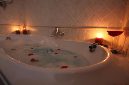 a bath tub with candles and a glass of wine at Porta del Vento in Giardini Naxos