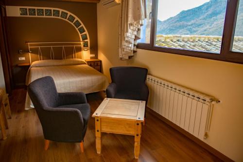 a bedroom with a bed and a chair and a table at CASA BERNAT in Aren