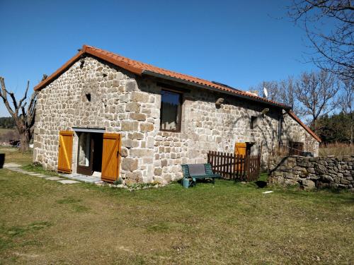 an old stone house with a bench in front of it at Les Fayettes in Montregard