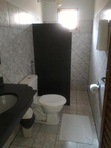 a bathroom with a white toilet and a sink at Pousada do Lajes in Carolina