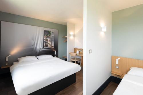 Un pat sau paturi într-o cameră la B&B HOTEL Evreux