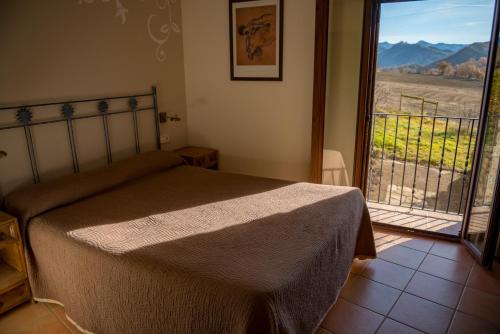 a bedroom with a bed and a balcony with a view at CASA BERNAT in Aren