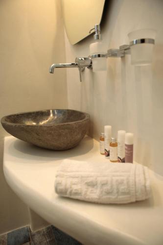 a bathroom counter with a sink and a towel at Naxos Petite Studios in Agios Prokopios