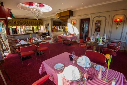 a restaurant with tables and chairs with pink tablecloths at Ringhotel Alpenhof - Patchworkhotel in Augsburg