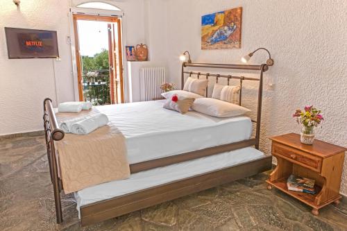 sypialnia z dużym łóżkiem z białą pościelą i poduszkami w obiekcie Villa Kastania w mieście Kastanéa