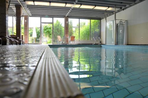 een zwembad met water in een gebouw bij Ringhotel Alpenhof - Patchworkhotel in Augsburg