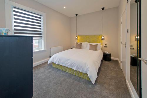 a bedroom with a large bed with a yellow headboard at Blackbird Luxury Apartments Room 2 in Blackpool