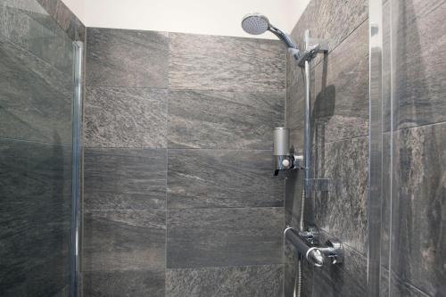 a shower in a bathroom with a stone wall at Blackbird Luxury Apartments Room 2 in Blackpool