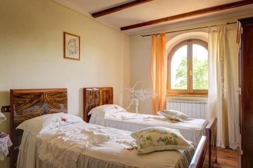 a room with two beds and a window at Villa Il Tollino in Sinalunga