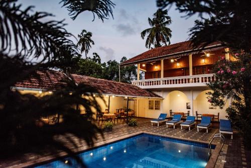 a villa with a swimming pool and a house at Dutch Bungalow in Cochin