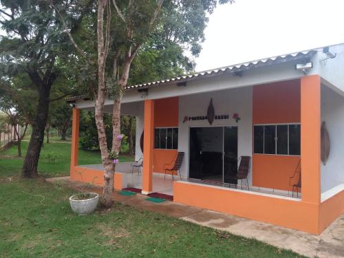 een klein huis met oranje en wit bij Chácara Pousada Sagui in Cuiabá