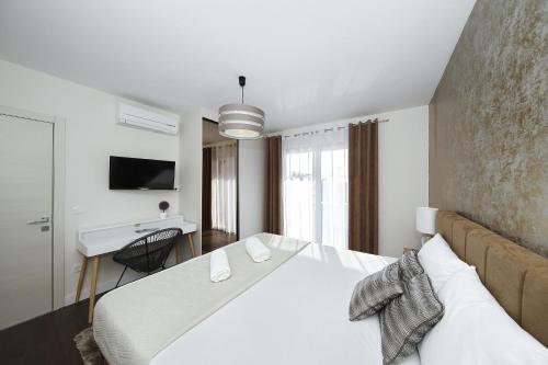 a bedroom with a large white bed and a desk at Villas A & N in Zaton
