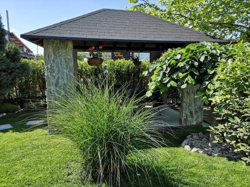 a gazebo in the middle of a garden at Villa i SPA Stević in Veliko Gradište
