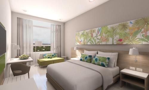 um quarto com uma cama branca e uma grande janela em Mia Hotel Choco em Quibdó
