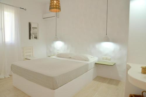 a white bedroom with a bed and a sink at Veletas Apartments in Adamantas