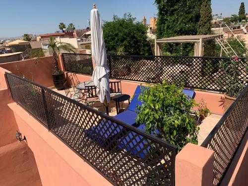 a balcony with an umbrella and a table and chairs at Riad Abaka hotel & boutique in Marrakech
