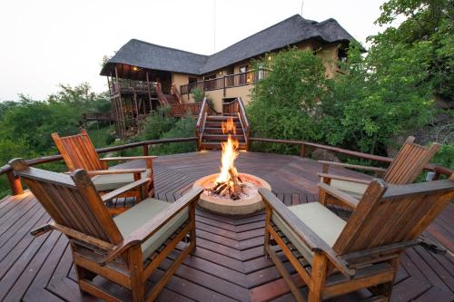 a deck with two chairs and a fire pit at Parsons House in Hoedspruit
