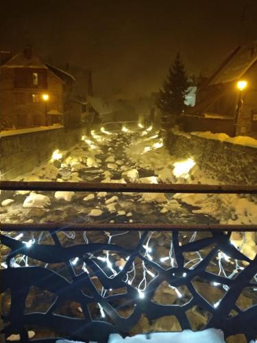 a snow covered path with lights in a city at night at CASA BERNAT in Aren