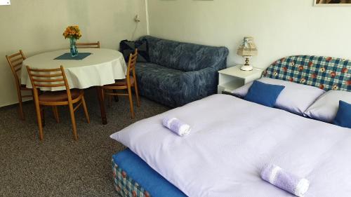 a room with a bed and a table and a couch at Konvalinka - ubytování v soukromí in Harrachov