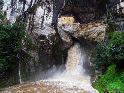 a building on the side of a mountain next to a waterfall at Hotel Cerro La Nina in Beceña
