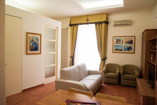 a living room with a white couch and a window at Casa del Grillo in Molfetta
