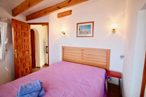 een slaapkamer met een bed met een paarse deken bij Don Quijote Studio SE in Denia