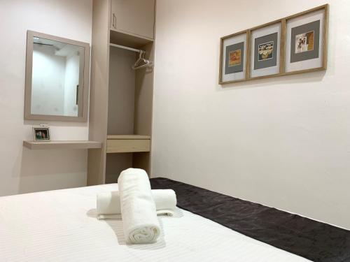 a bathroom with a bed with a mirror and a towel at Langkawi Cozy Holiday Home at Bukit Indah by Zervin in Kuah