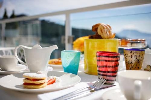 a table with a plate of food and cups and utensils at Villa Fiorella Art Hotel in Massa Lubrense