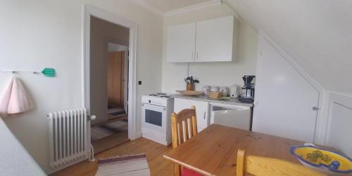 una pequeña cocina con mesa de madera y comedor en My Bureau Apartment, en Korsør