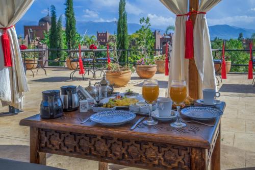 a wooden table with food and drinks on a patio at Taj Atlas Wellness Boutique Hôtel & Spa in Amizmiz