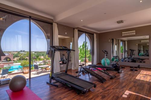 a gym with a bunch of treadmills and exercise bikes at Taj Atlas Wellness Boutique Hôtel & Spa in Amizmiz
