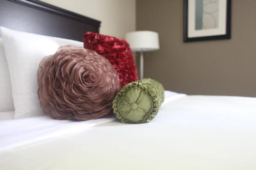 two pillows sitting on top of a bed at Eastland Suites Hotel & Conference Ctr, Trademark by Wyndham in Bloomington
