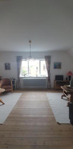 an empty living room with a large window at My Bureau Apartment in Korsør